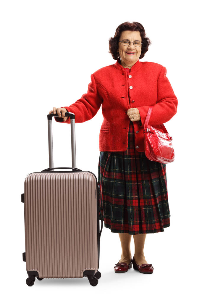 Egy idős nő teljes hosszúságú portréja fehér alapon elszigetelt bőrönddel - Fotó, kép