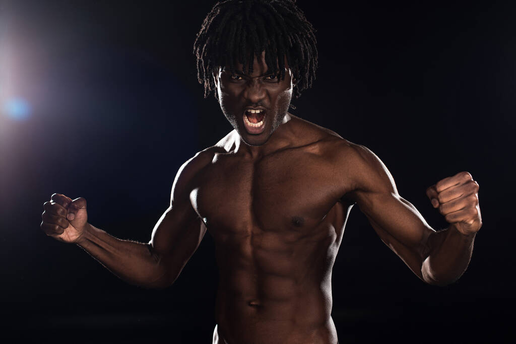 muscoloso emotivo afroamericano uomo urlando sul nero con luce posteriore
 - Foto, immagini