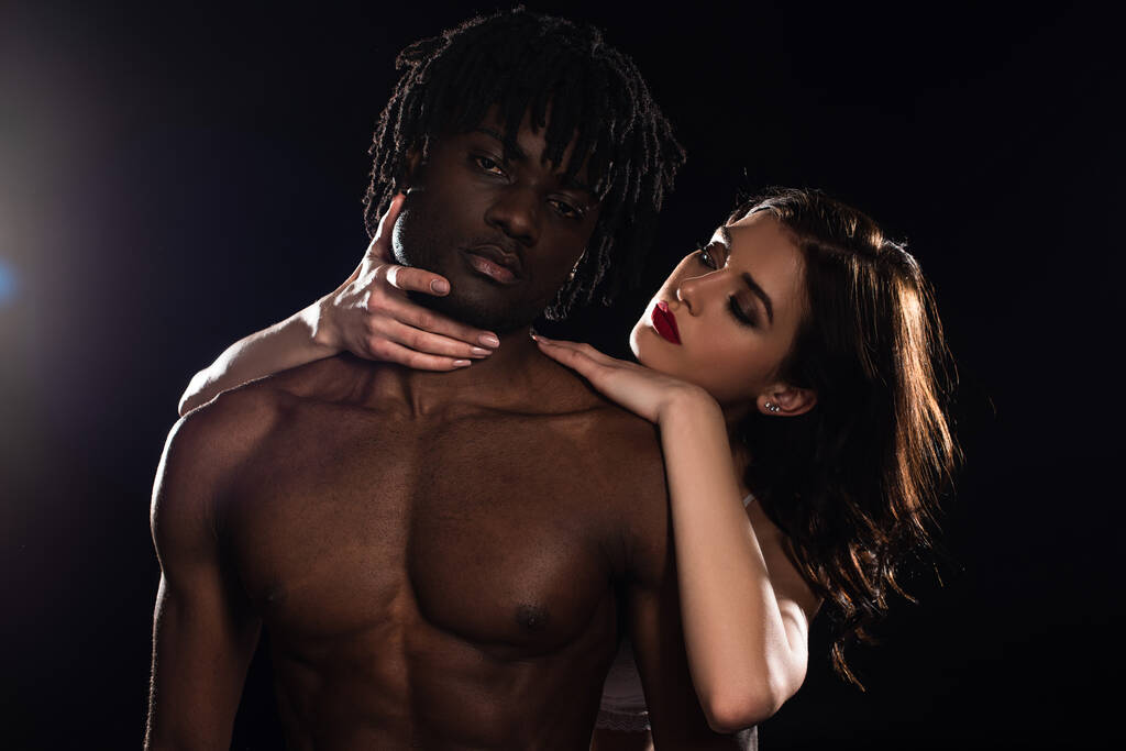 passionate interracial couple in underwear hugging isolated on black - Photo, Image