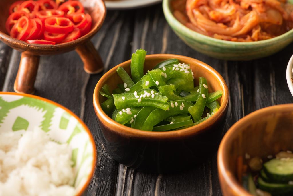 selektivní zaměření zelené papriky a červené chilli papričky v blízkosti korejských kimchi a rýže - Fotografie, Obrázek