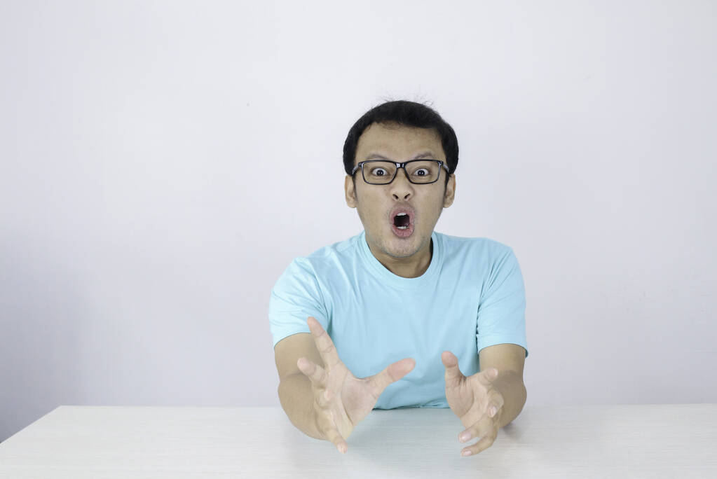 Ого і шоковане обличчя молодого азіатського чоловіка з відкритим жестом. Рекламна модель концепції з синьою сорочкою. - Фото, зображення