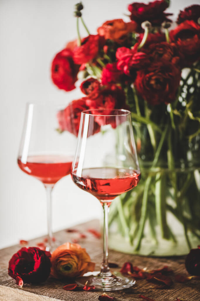 Vinho rosa em copos e flores de flor de primavera vermelha buquê sobre fundo de mesa de madeira rústica, foco seletivo. Loja de vinhos, bar, degustação de vinhos, conceito de carta de vinhos - Foto, Imagem