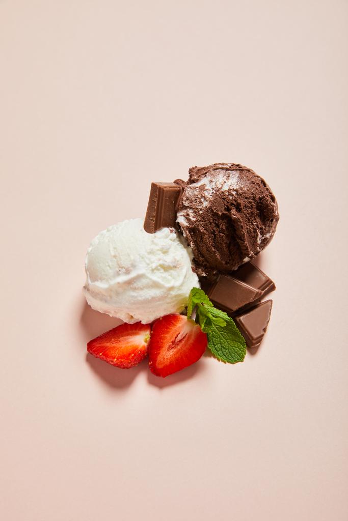 вид сверху на свежий вкусный белый и шоколадный шарики мороженого с мятой и клубникой на розовом фоне
 - Фото, изображение