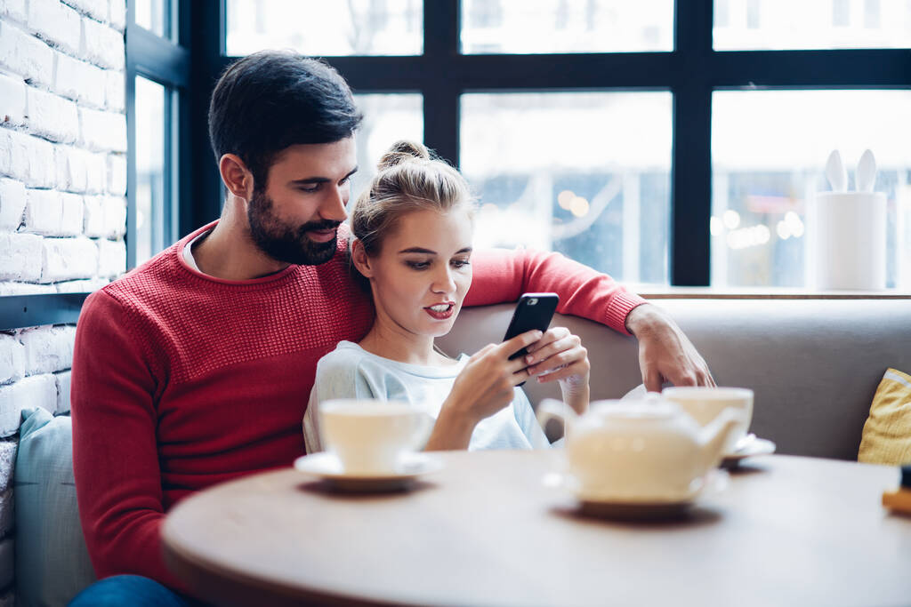 Generation couple in love reading received email with invitation text for married pairs connected to 4g wireless on cellphone device, Caucasian husband and wife chatting and browsing websites via app - Photo, Image