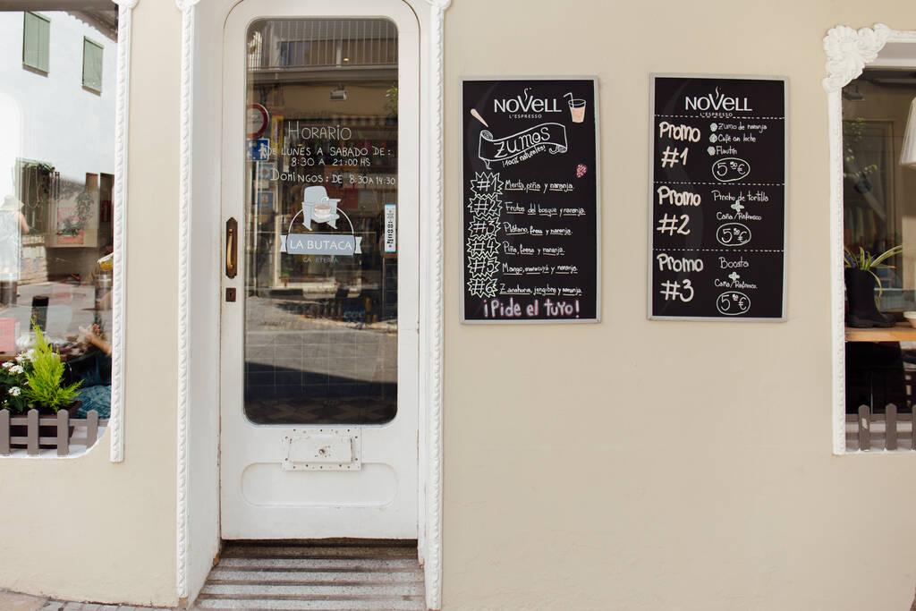 KATALONIEN, SPANIEN - 30. APRIL 2020: Schilder mit Speisekarte an der Wand neben der Tür im Café - Foto, Bild