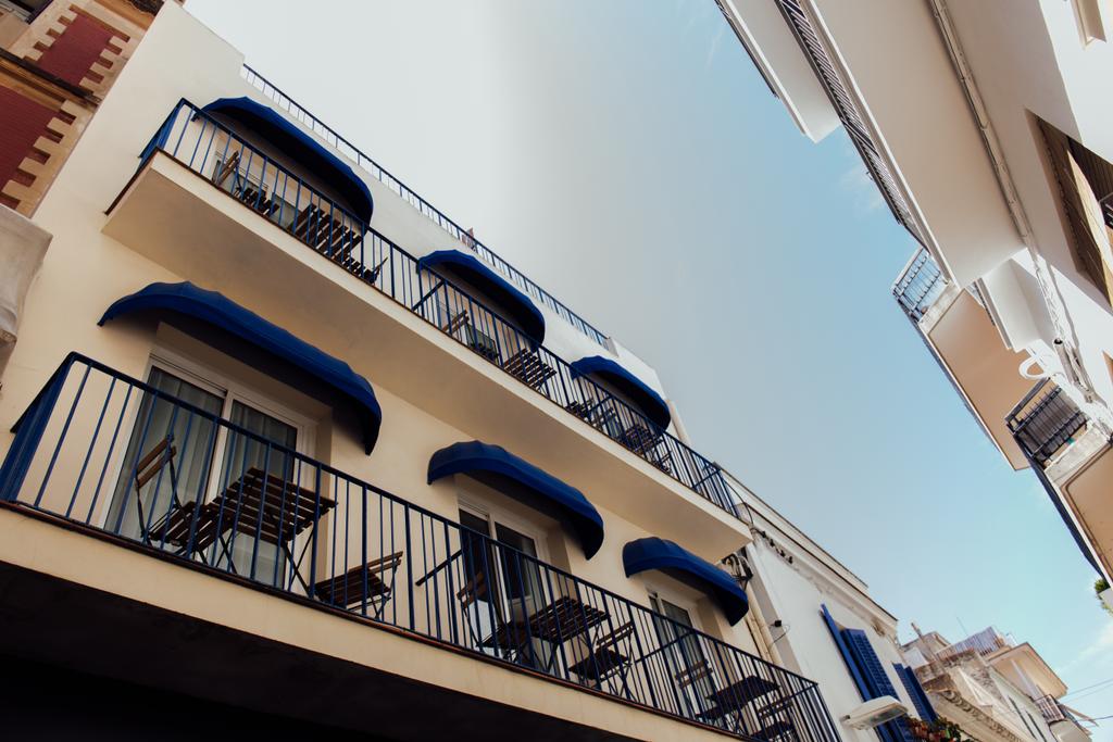 Alhainen kulma näkymä pöytiin ja tuoleihin parvekkeella rakennuksen sininen taivas taustalla Kataloniassa, Espanjassa
  - Valokuva, kuva