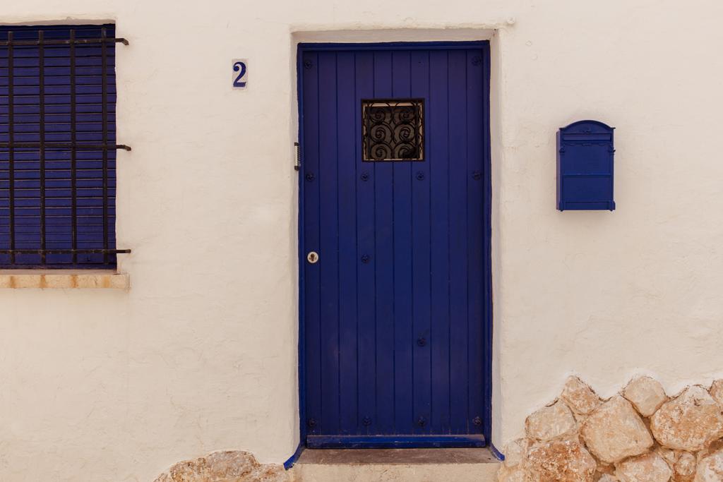 Синя поштова скринька та дерев "яні двері біля будинку в Каталонії (Іспанія).   - Фото, зображення