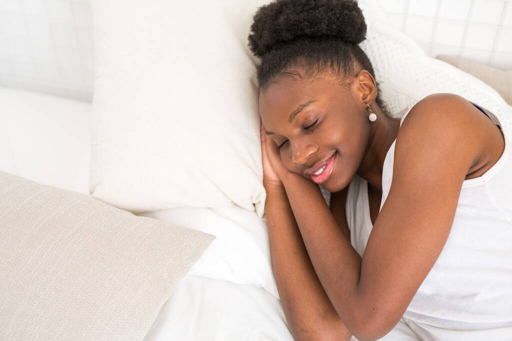  красива молода африканська жінка спить на білому ліжку
 - Фото, зображення