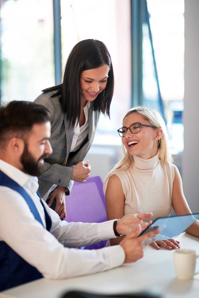 Bürokollegen lächeln, während sie Geschäfte besprechen, freundliche Geschäftsatmosphäre - Foto, Bild