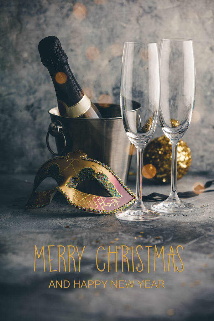 Botella de champán en cubo con hielo, vasos y decoraciones navideñas - Foto, imagen