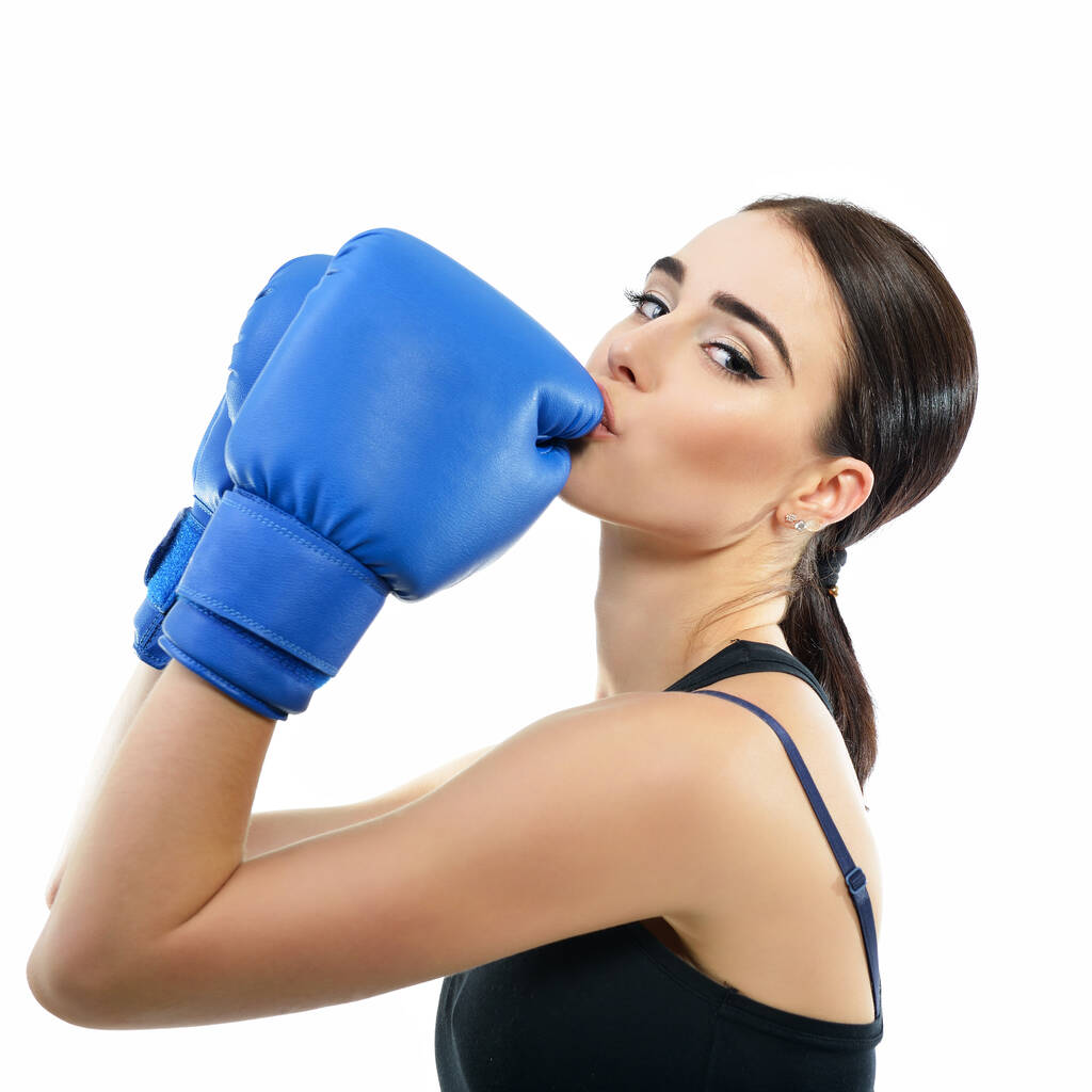 スポーツ少女ボクシングの練習をしている。若い女性の写真は白い背景に隔離された彼女のボクシングの手袋にキス。強さ、動機、健康と美しさ. - 写真・画像