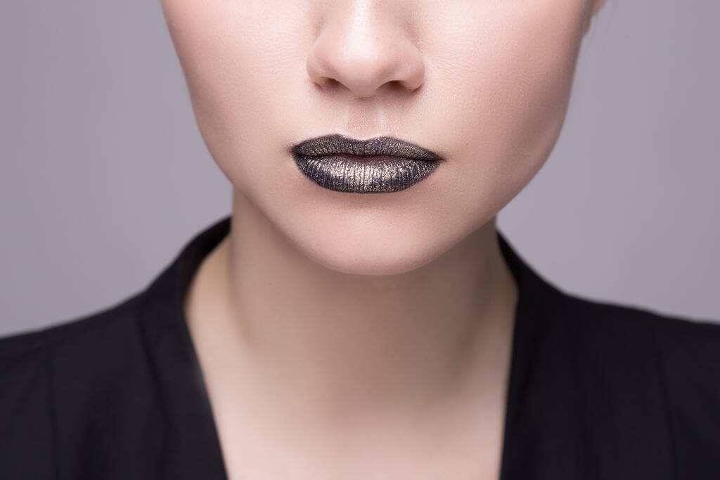 Zwarte lippen, zwarte vloeistof druppels op mooie model meisjes mond. schoonheid vrouw gezicht make-up close-up - Foto, afbeelding