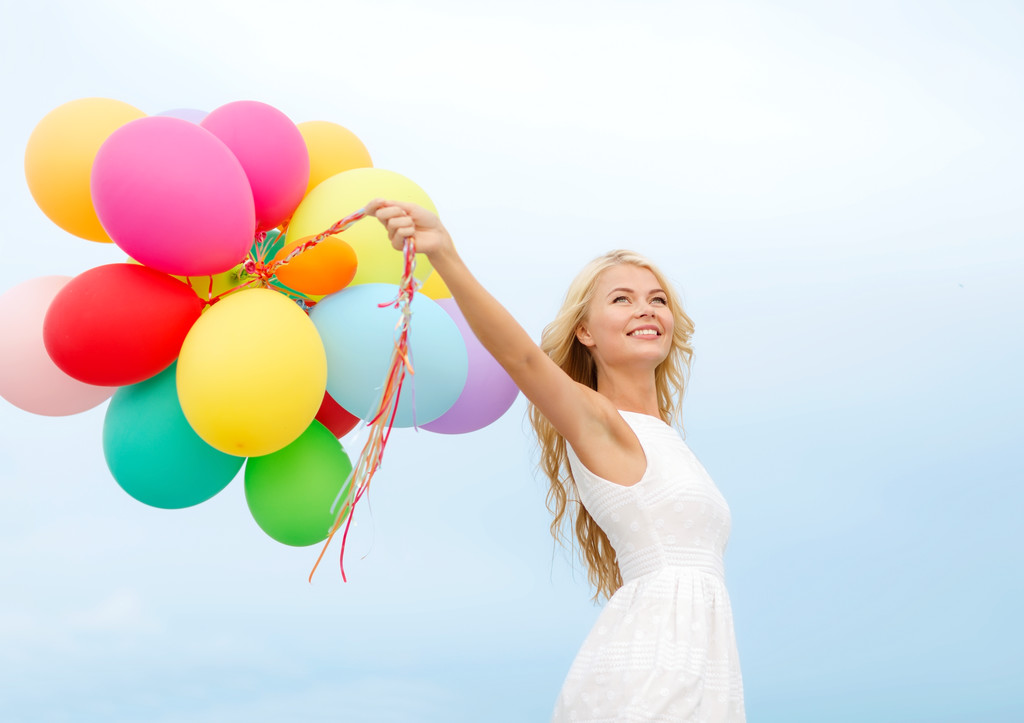 Lachende vrouw met kleurrijke ballonnen buiten - Foto, afbeelding