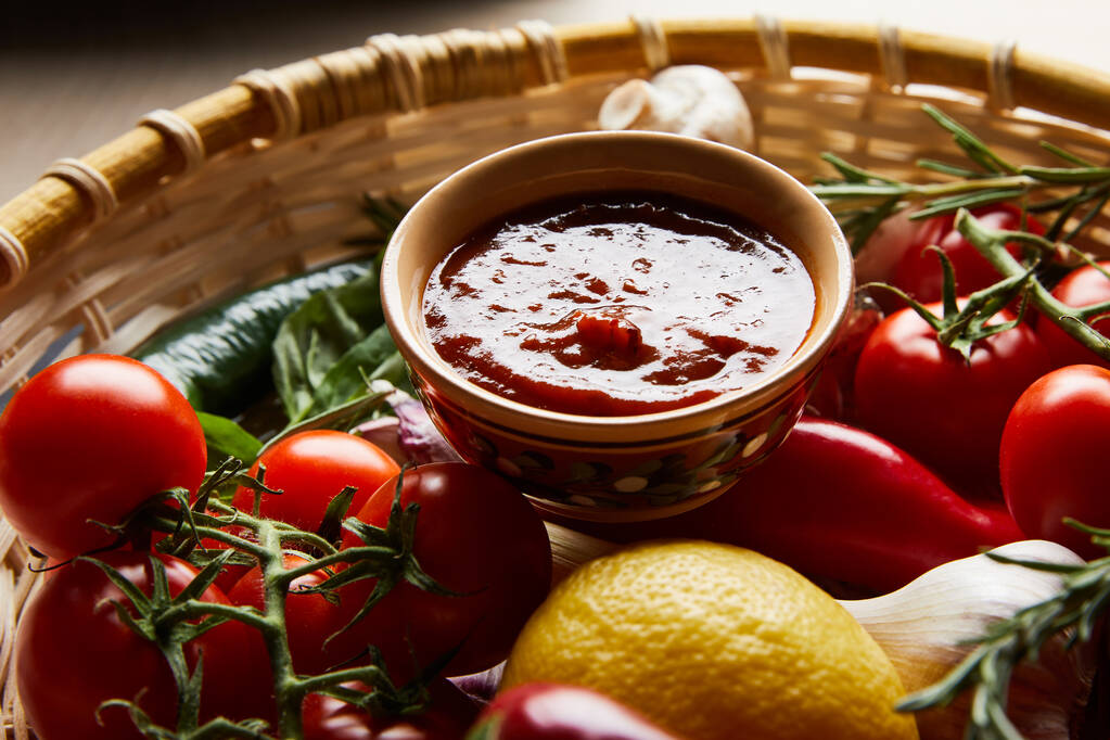 близкий вид на вкусный томатный соус со свежими зрелыми овощами в корзине
 - Фото, изображение