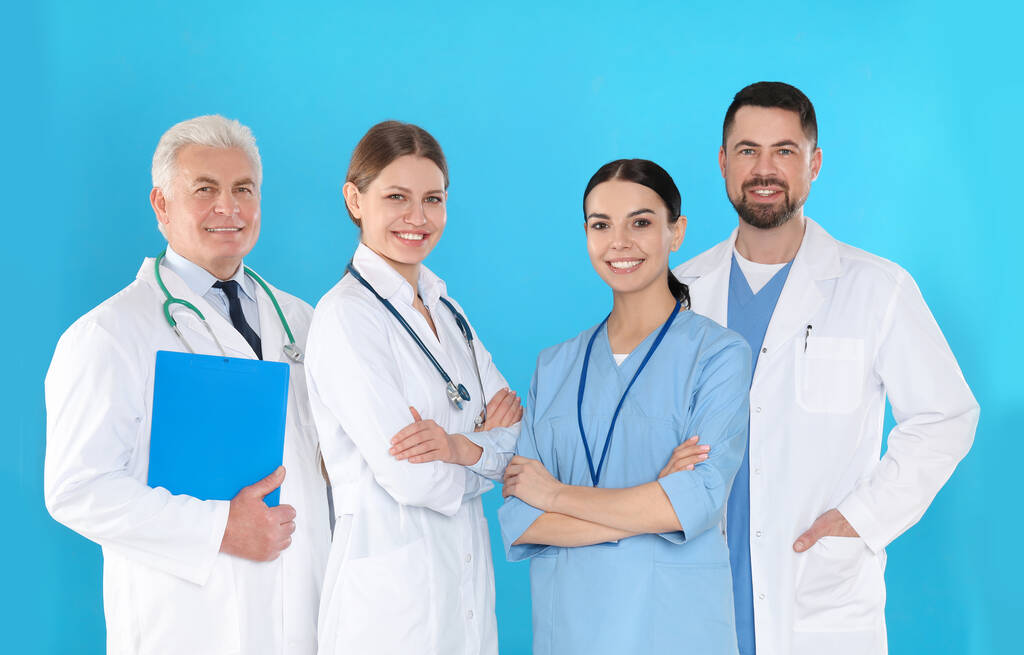 青い背景を持つ医師のグループ。医療サービス - 写真・画像