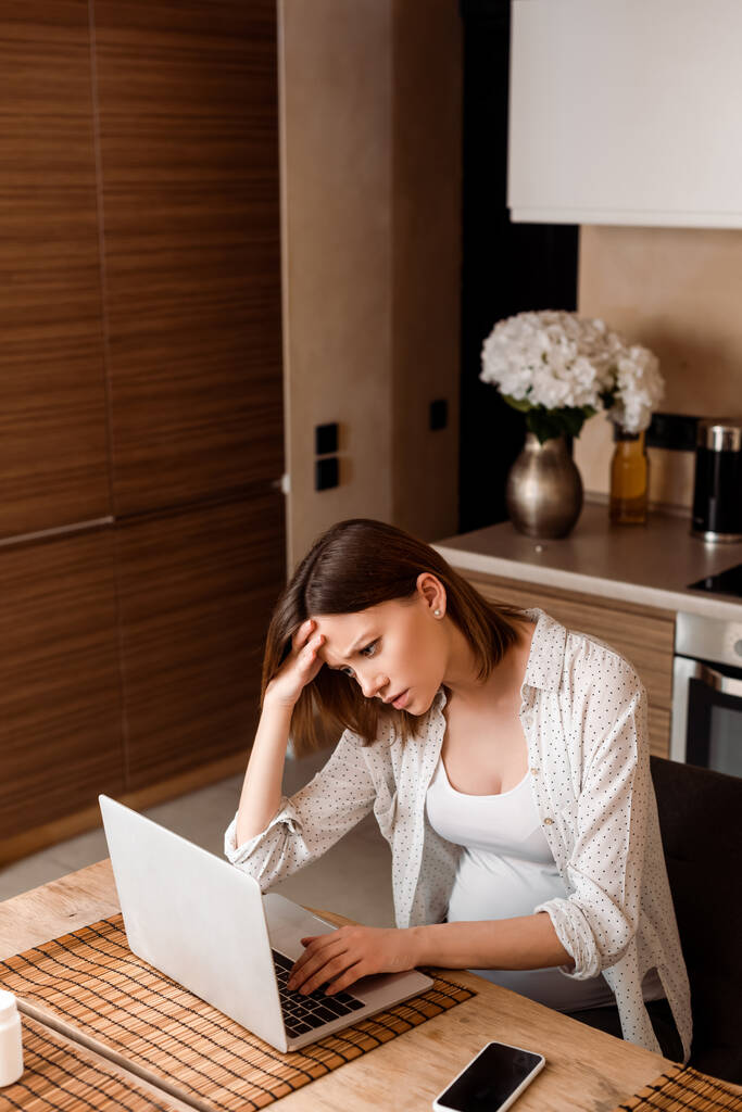 väsynyt ja raskaana freelancer käyttäen kannettavaa tietokonetta kotona
 - Valokuva, kuva