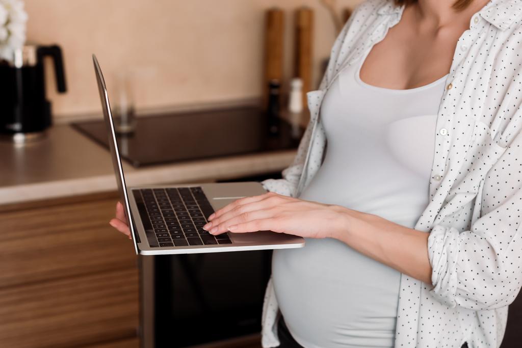 обрезанный вид беременной фрилансеры с помощью ноутбука
  - Фото, изображение