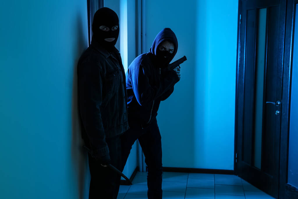 Peligrosos criminales con pistola y barra de cuervo en el pasillo
 - Foto, imagen