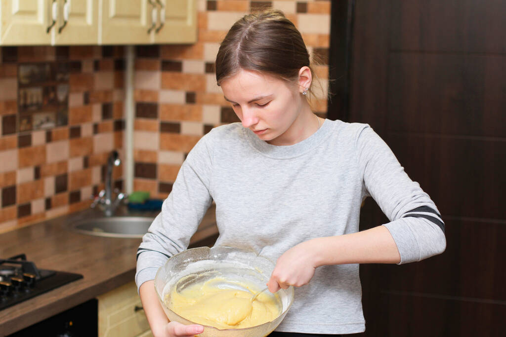 A lány gyúrja a tésztát. A lány főz. A kezek tésztát készítenek. Friss tésztát gyúró nő - Fotó, kép