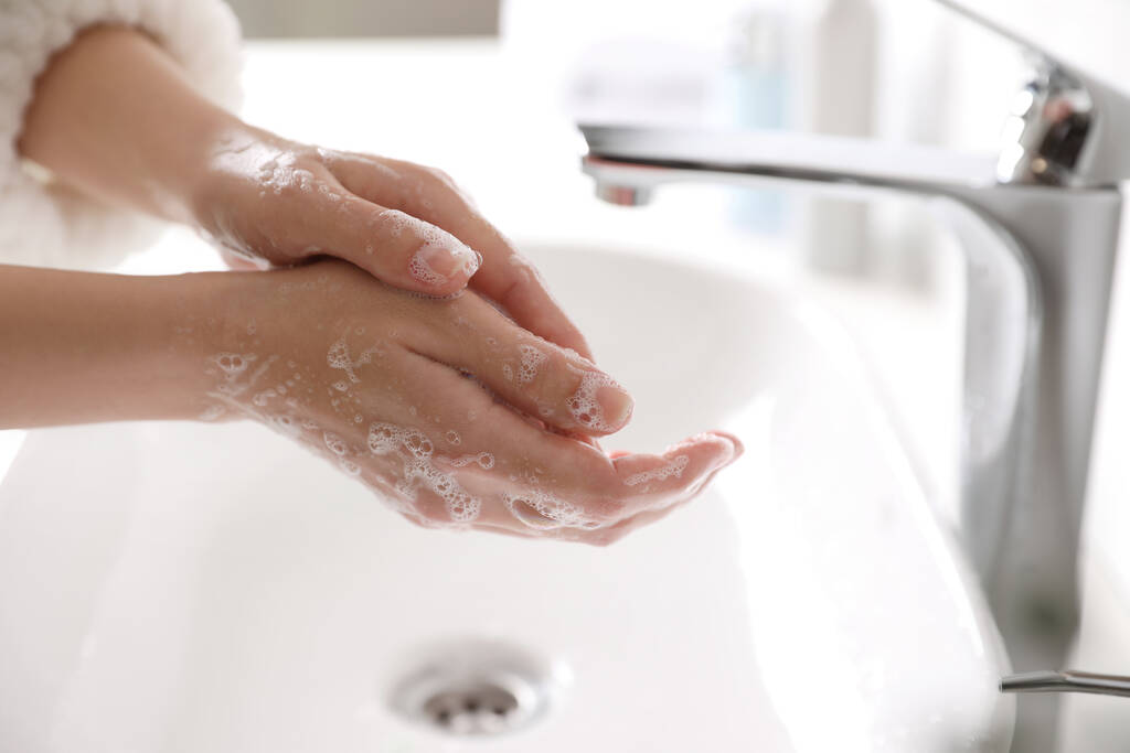 Femme se lavant les mains avec du savon sur l'évier dans la salle de bain, gros plan
 - Photo, image