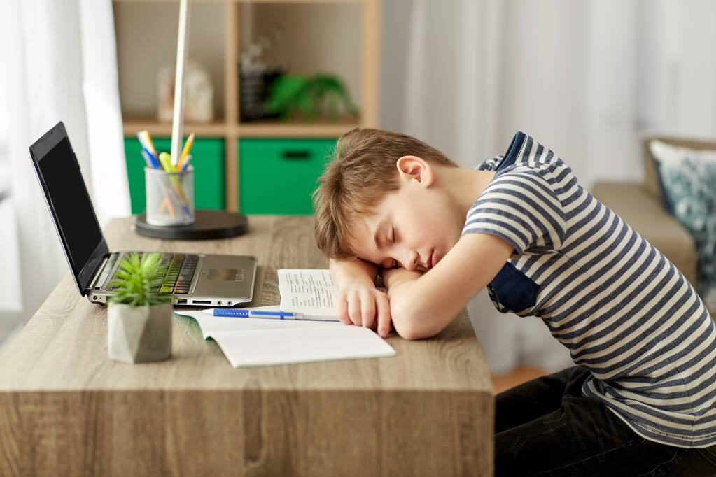 κουρασμένος μαθητής αγόρι κοιμάται στο γραφείο στο σπίτι - Φωτογραφία, εικόνα