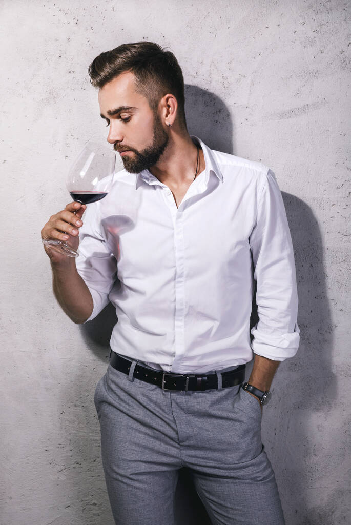 Yakışıklı sakallı şarap garsonu kırmızı şarap tadıyor. - Fotoğraf, Görsel