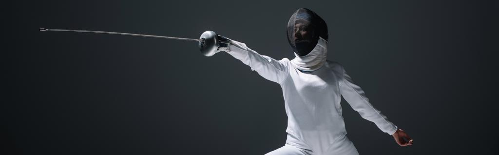 Panorâmica tiro de esgrima em esgrima terno e máscara exercício isolado em preto
  - Foto, Imagem