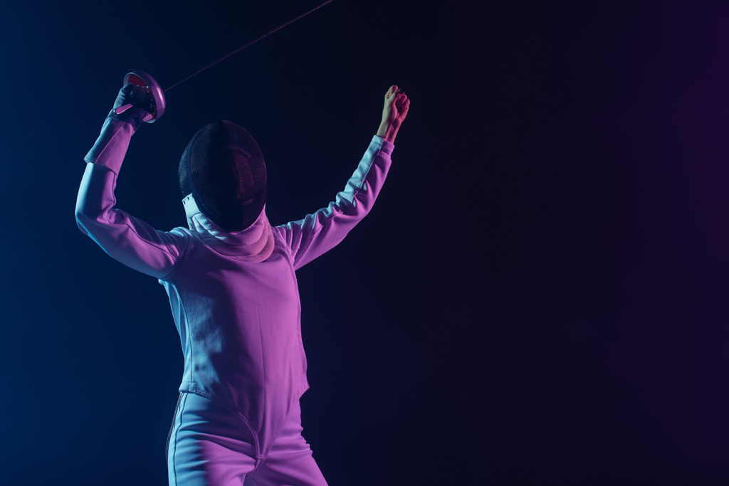 Fencer in fencing mask holding rapier while showing yes gesture isolated on black  - Photo, Image