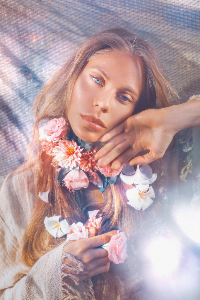 柔らかい布の下に首に花を持つ美しい若い女性 - 写真・画像