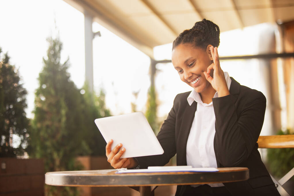Afroamerykańska bizneswoman w stroju biurowym uśmiecha się, wygląda pewnie i szczęśliwie, odnosi sukcesy - Zdjęcie, obraz