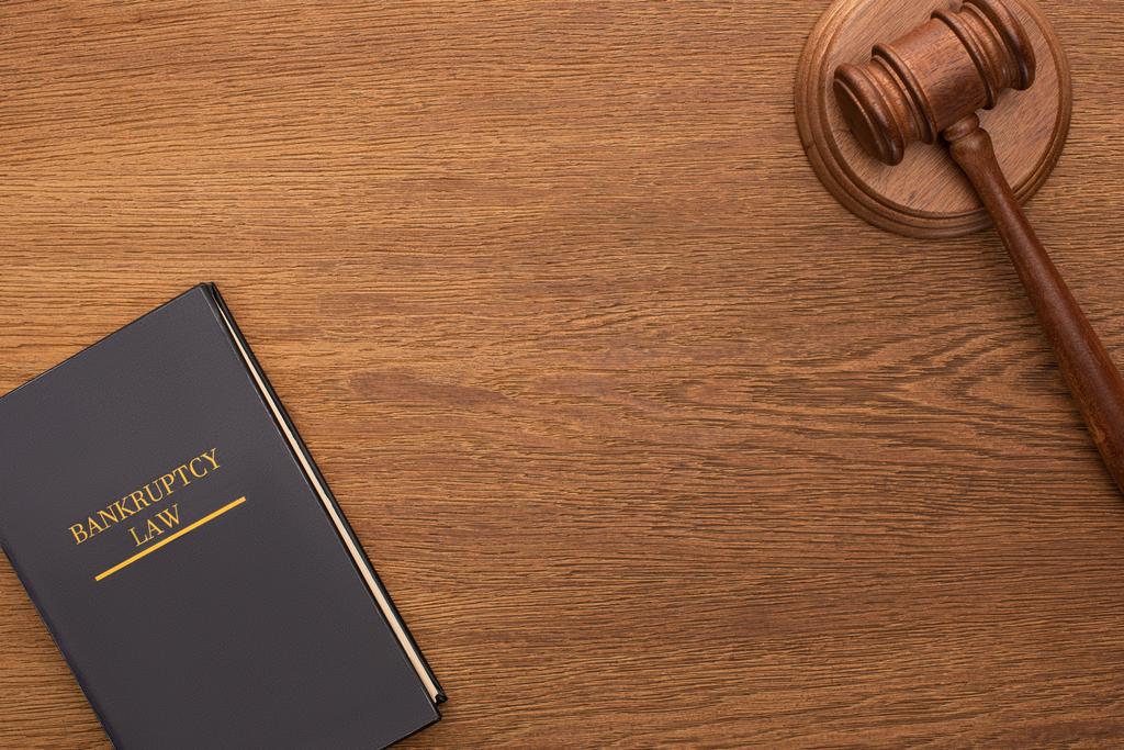 Top view of bankruptcy law book and gavel on wooden background
 - Фото, изображение