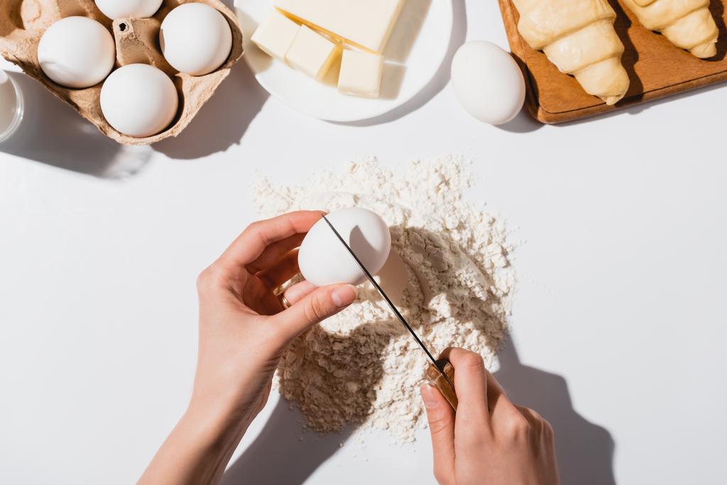 vista cortada de mulher fazendo massa para croissants no fundo branco
 - Foto, Imagem