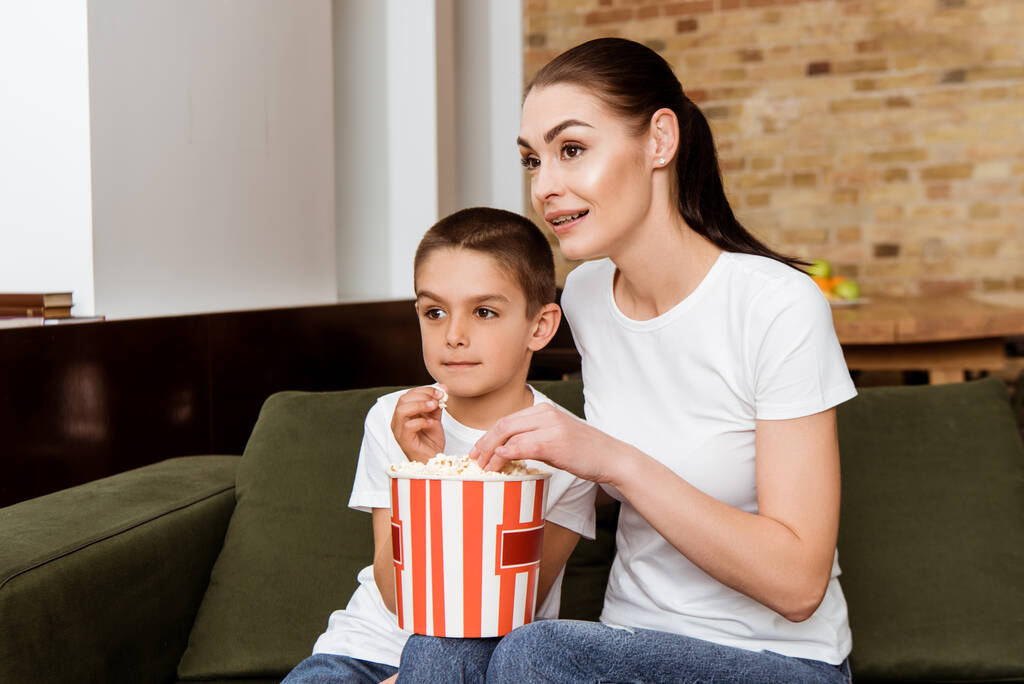Mère et fils manger du pop-corn tout en regardant le film à la maison
  - Photo, image