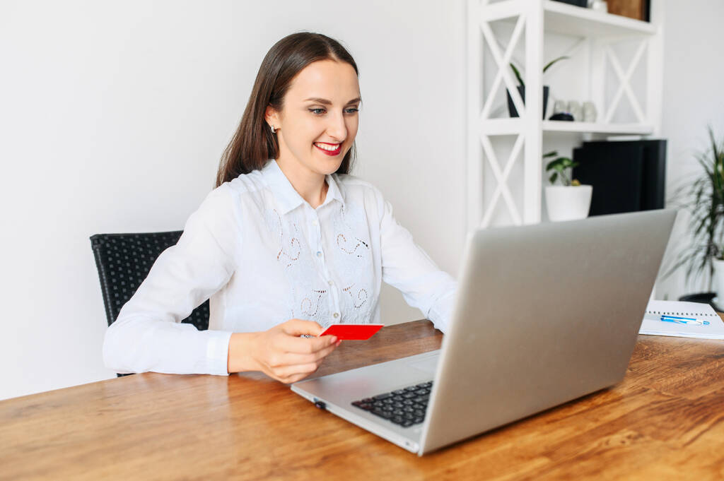 Uma jovem com um cartão de crédito usando laptop
 - Foto, Imagem