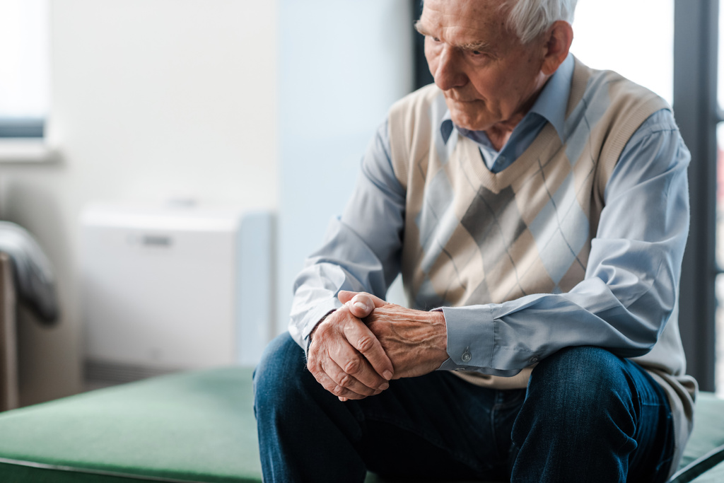 smutný starší muž sedí sám na pohovce během vlastní izolace - Fotografie, Obrázek