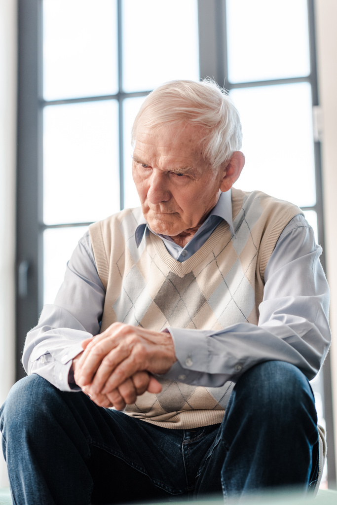 rozrušený starší muž sedí sám na pohovce během vlastní izolace - Fotografie, Obrázek