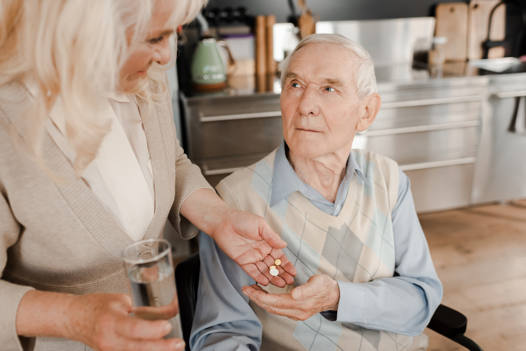 esposa idosa e marido doente com pílulas e copo de água em casa durante a quarentena
 - Foto, Imagem