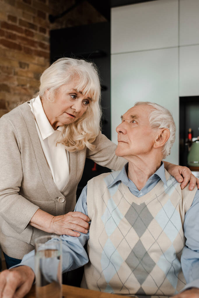 esposa anciana y marido enfermo con vaso de agua en casa durante la cuarentena
 - Foto, Imagen