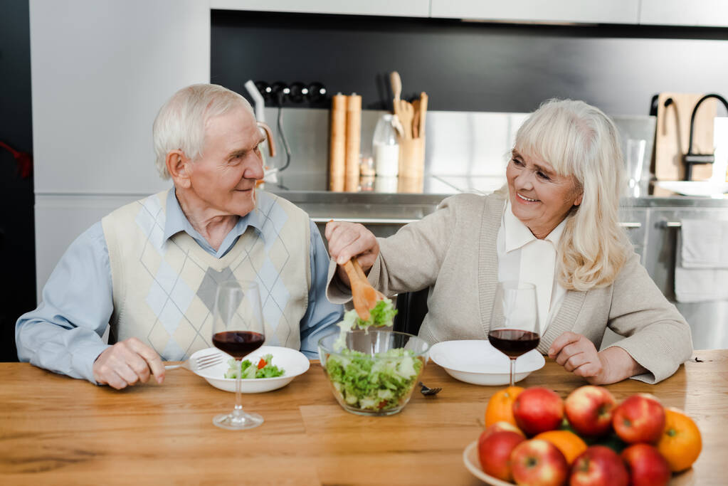felice moglie anziana e marito a cena con vino e insalata a casa in quarantena
 - Foto, immagini