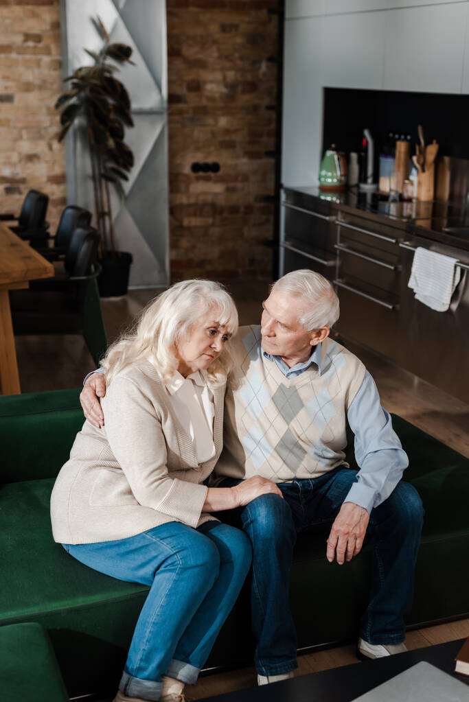 traurige ältere Frau und Mann umarmen sich und sitzen zu Hause unter Quarantäne - Foto, Bild