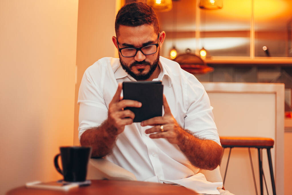Muž uvolňuje čtení knihy na e-book reader u sebe doma - Fotografie, Obrázek