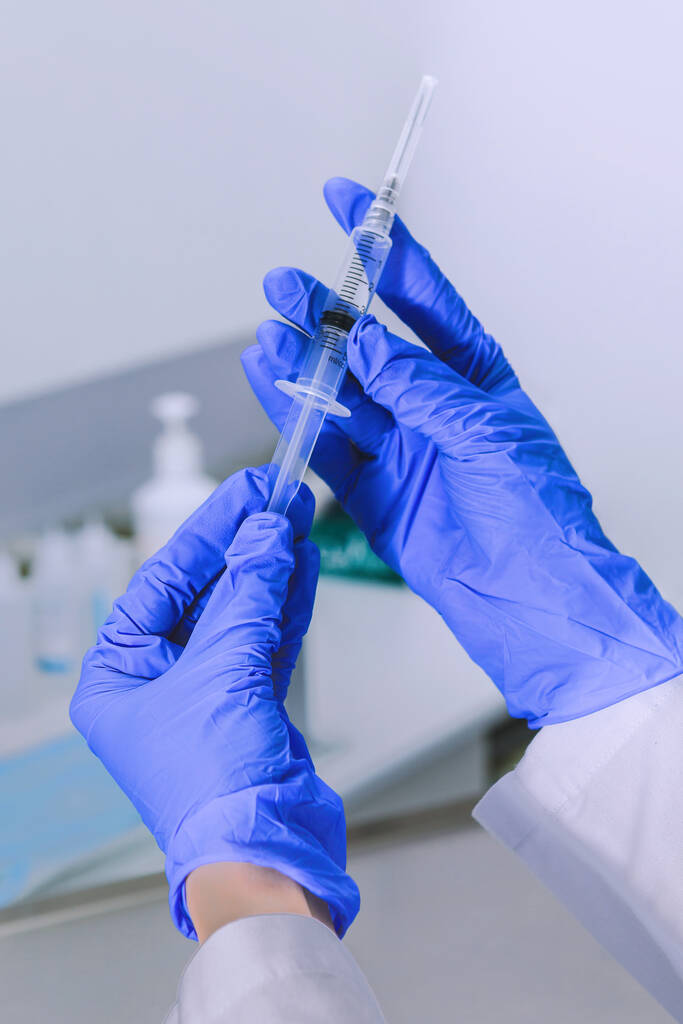 Sterile medicine equipment. Doctor wearing sterile blue gloves opening sterile medical needle syringe. Hands close-up - Photo, Image