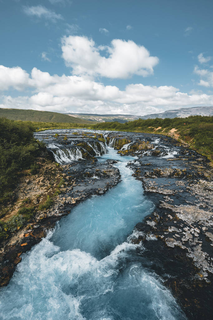 Increíble vista de la cascada Bruarfoss. La cascada más azul de Islandia. El agua azul fluye sobre las piedras. Sol de medianoche de Islandia. Visita Islandia. Mundo de belleza
. - Foto, Imagen
