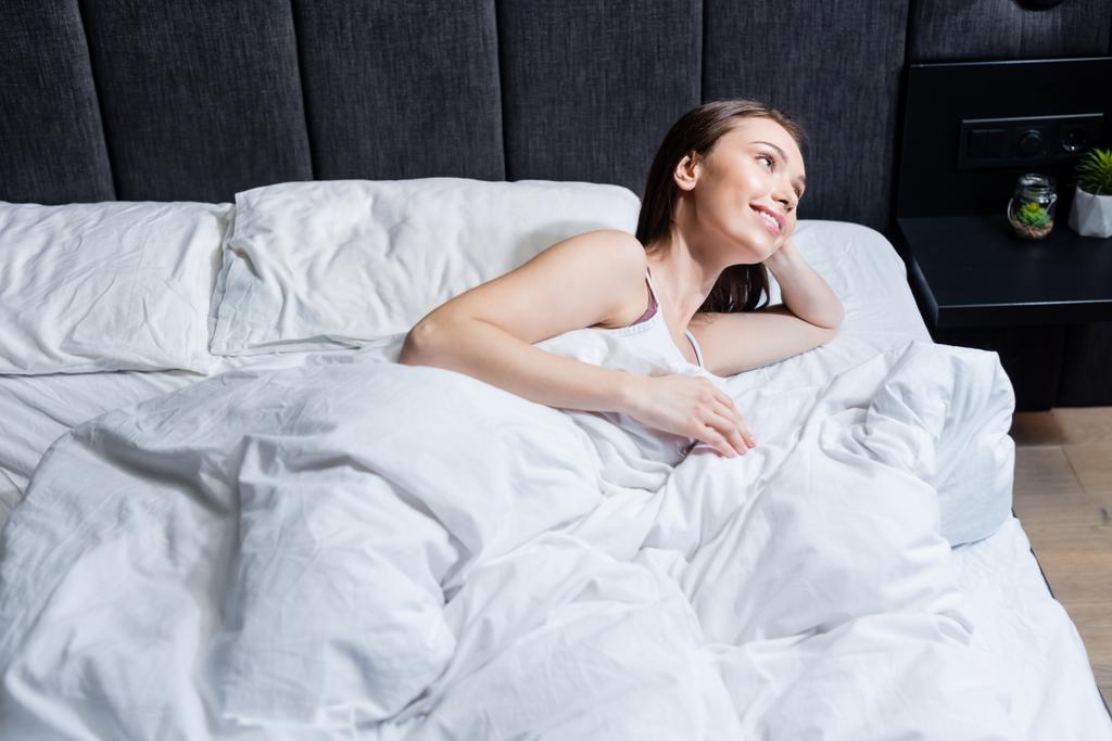 donna allegra guardando lontano e sdraiato sul letto
 - Foto, immagini