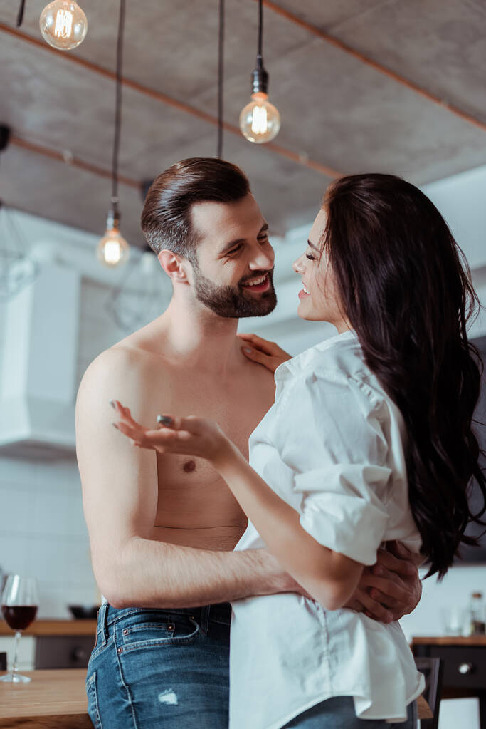 happy woman with sexy shirtless boyfriend in kitchen - Photo, Image