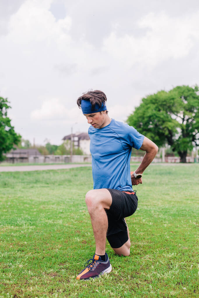 Αθλητής κάνει προθέρμανση πριν από το τρέξιμο στο γήπεδο - Φωτογραφία, εικόνα