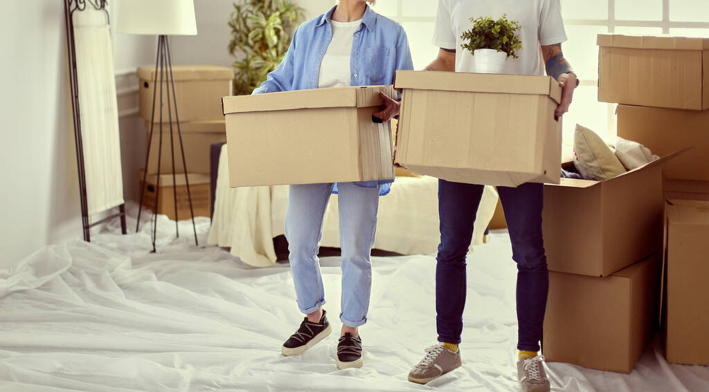 Ζευγάρι κρατώντας κουτιά για τη μετακίνηση των χεριών και κοιτάζοντας μέσα στο κουτί - Φωτογραφία, εικόνα