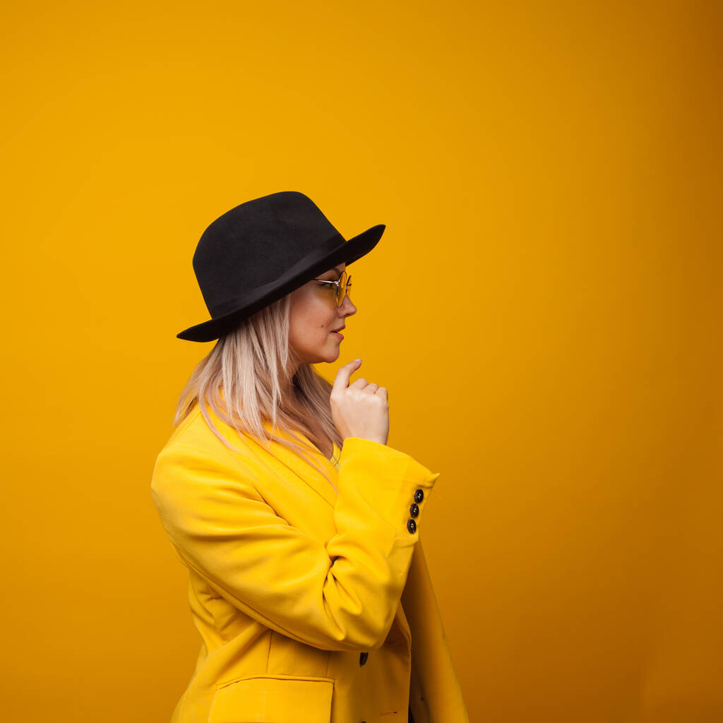 Veselá trendy mladá žena v zářivé šaty na žlutém pozadí, kopírovat prostor. Cool blondýnka - Fotografie, Obrázek