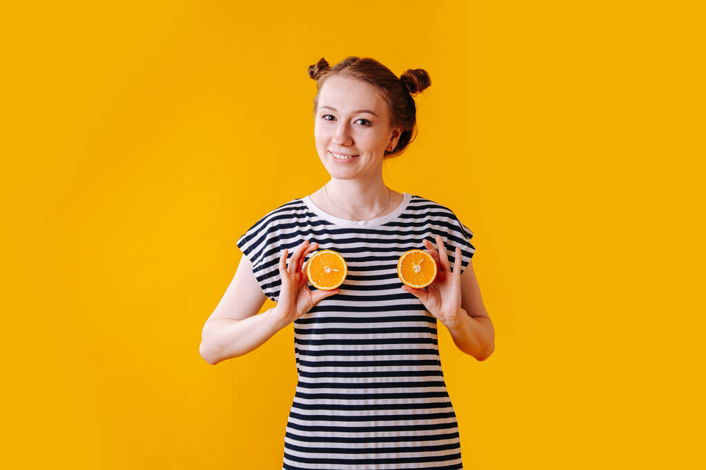Engraçado jovem retratando seu peito com metades de laranjas
 - Foto, Imagem