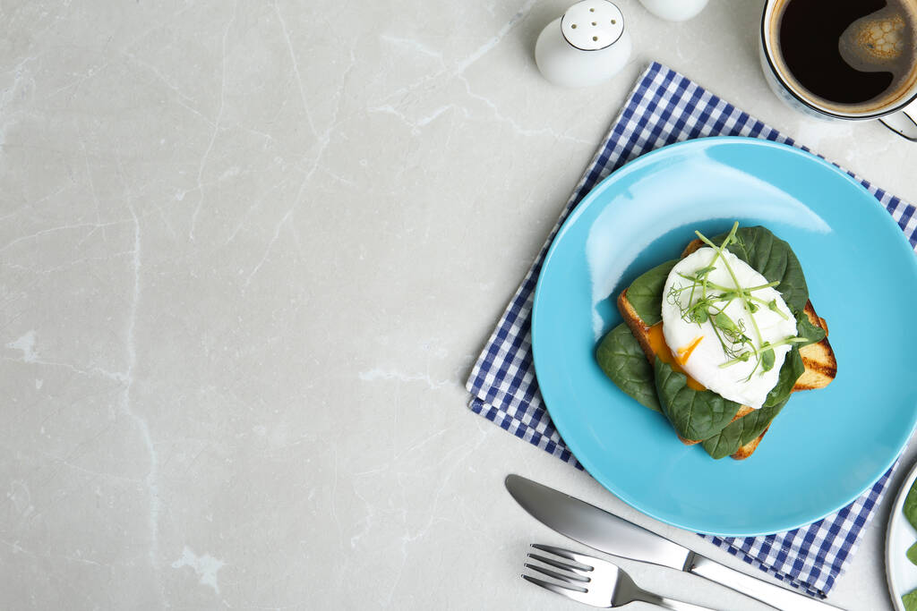 Delicious poached egg sandwich served on light grey marble table, flat lay. Space for text - Photo, Image